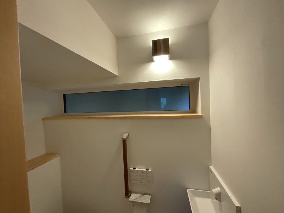 階段下の１階トイレ。このお宅は照明器具が上手に選定されているので、ご来場の方はぜひそのあたりも参考にしてみてください。